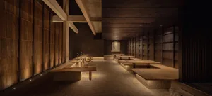 Dimly lit restaurant with multiple dining tables and benches, adorned with artwork on the walls
