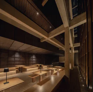 A calm and inviting study space with multiple tables and chairs, wooden floor, and minimal decor