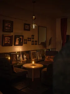 Cozy modern dining space with a dining table, two couches, and a candle, dimly lit for ambiance