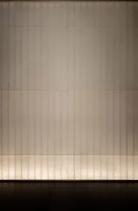 A concrete wall with a row of evenly spaced small windows, creating a functional and practical design