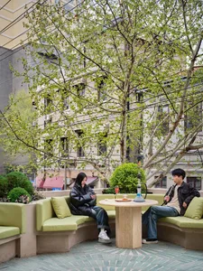 A well-lit outdoor patio with a dining table and chairs, surrounded by a comfortable seating area for two people
