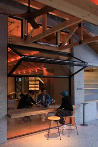 溫暖親切的餐廳環境，人們圍坐在餐桌旁享用美食與飲品，伴隨著一隻狗狗