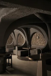 Cozy restaurant interior with stone walls, wooden furniture, and warm lighting