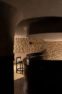 A cozy bar area with a round table and chairs, a bar counter, and inviting ambiance
