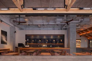 Modern wine bar with a bar area and chairs, tables, and bottles throughout, inviting atmosphere