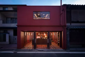 Inviting restaurant interior with a red exterior wall, dining tables, chairs, and cups, providing a comfortable dining experience