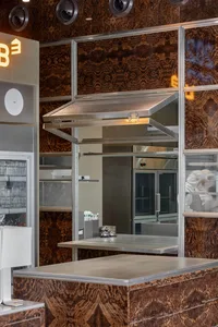 Industrial kitchen with stainless steel table, ovens, and sinks, giving a clean and modern appearance