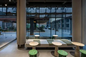 A warm and inviting indoor seating area with multiple wooden tables and chairs, perfect for social gatherings or relaxation
