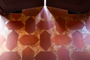 A warm and inviting space with a red brick or stone floor featuring triangular patterns and a cozy atmosphere