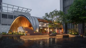 A modern interior space with a large glass wall, comfortable seating area, and natural light