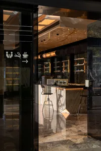 A cozy cafe counter with two chairs, one on each side, and a marble surface, set in a warm and inviting atmosphere
