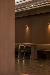 Warm and inviting restaurant interior with wooden walls and floors, featuring comfortable seating and dining tables