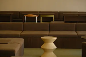 Comfortable living area with multiple couches and chairs, wooden and leather furniture, and natural light from windows