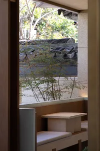 Interior view of a room with two tables, a bench, and a wooden theme, with natural light coming in from outside