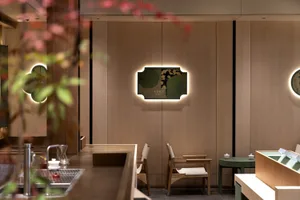 Cozy modern restaurant interior with wooden floors and walls, dining tables, chairs, and a large picture on the wall
