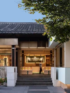 Inviting restaurant interior with wooden furniture, multiple seating areas, and bottles on display