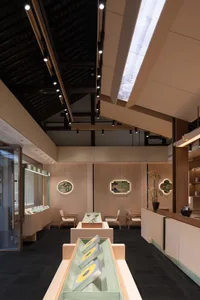 A modern interior design showroom with a large wooden ceiling and walls, featuring chairs and dining tables, with a warm and inviting atmosphere