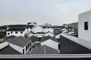 Aerial view of a densely populated city with white buildings, varied roof structures, and a vibrant atmosphere