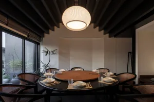A cozy dining area with a round wooden table surrounded by chairs, creating a warm and inviting atmosphere for socializing and meals