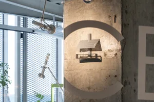現代住宅前方具圓形設計元素，採用混凝土與金屬材質，灰白配色，上方明亮通風採光