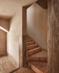 A warm and inviting wooden staircase with brown treads and risers, set against a neutral background