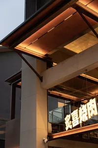 Contemporary Asian building with a large concrete overhang, glass window, and modern facade