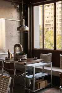 Modern living area with a dining table, chairs, and a couch near a window