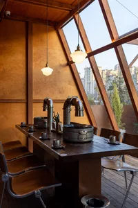 Modern kitchen dining space with a wooden table, two sinks, and a sleek design