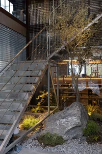 A minimalist staircase with metal steps leading to a second floor, set against a bright and airy background
