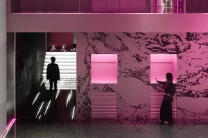 A modern interior space with a staircase, pink and white colors, and bold contrasting elements