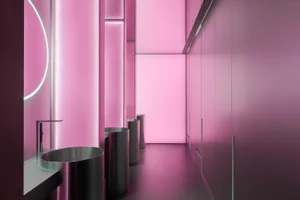 Pink bathroom with silver trash cans and modern minimalist design