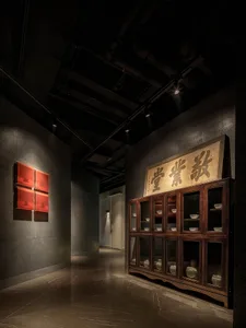 Dimly lit study with a wooden cabinet featuring oriental-style drawers and compartments, surrounded by elegant design elements