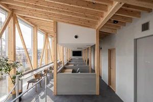 A warm and inviting dining space with wooden beams, a high ceiling, and multiple chairs