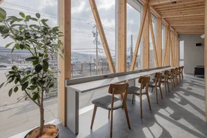 Open modern living space with wooden elements, a large window, and natural light from the window