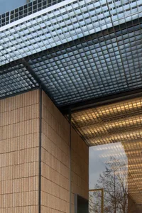 A modern building exterior with a large glass window allowing natural light to enter, creating a bright and airy atmosphere