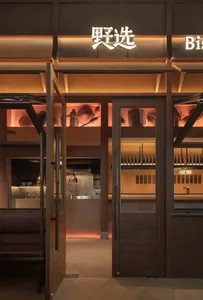 Warm and inviting restaurant kitchen with wooden walls and floors, featuring wine glasses on a countertop