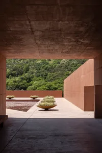 A grand building with a stone facade, featuring three vases on the ground outside, adding to its aesthetic appeal