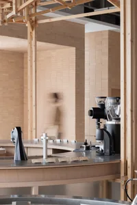 A modern coffee shop interior with two espresso machines and a cup, featuring a well-organized atmosphere