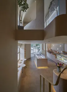 Open modern kitchen and dining area with natural light, a large window, a counter, sink, dining table, chairs, and potted plants
