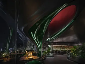 A sophisticated dining space with tables, chairs, and potted plants, set in a well-designed restaurant with attention to detail
