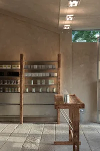 A retail store with shelves displaying various items, including bottles and cups, in a well-stocked environment