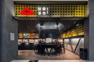 Modern Asian restaurant with black and yellow tones, comfortable seating, and a unique triangle decorative element