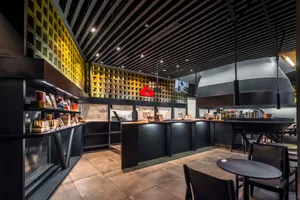 Modern interior design showroom with black and white tiles, chairs, and tables, featuring a clean and sophisticated atmosphere with books and a professional appearance