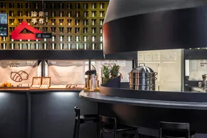 A modern Asian restaurant with a black theme, featuring a counter with stools and decorative walls