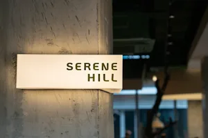A dimly lit interior space with a modern sign reading Seren Hill on the wall