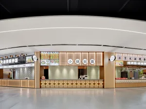 A modern Asian restaurant with a clean and minimalist design, featuring white walls, wooden accents, and a large dining area with a counter and seating for customers
