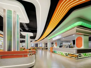 Bright and inviting restaurant interior with orange and white walls, green accents, and multiple dining tables and chairs