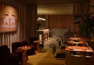 Cozy restaurant with a mix of seating options, potted plants, and comfortable atmosphere