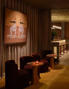 Cozy restaurant interior with red chairs and tables, inviting atmosphere, and warm lighting