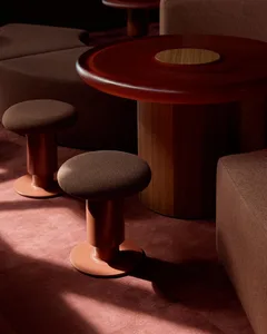 A warm and inviting living area with a wooden table surrounded by leather-covered stools